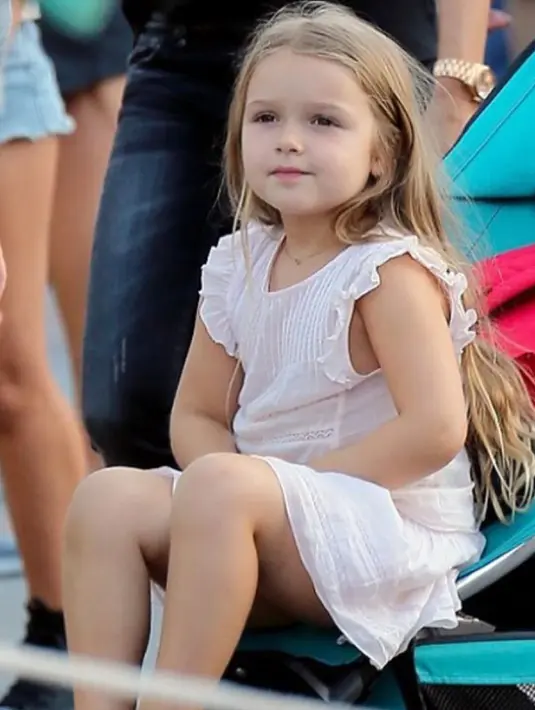 Harper Beckham terlihat di Disneyland, Amerika pada 24 Agustus 2015. Harper tampil manis dengan menggunakan dress putih polos. (harperbeckhamfashion)
