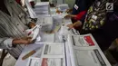 Sejumlah pekerja melipat surat suara Pemilihan Umum 2019 di gudang logistik KPU Jakarta Pusat, Selasa (19/2). Tugas pertama para pekerja ialah menyortir surat suara antara surat suara yang cacat dan yang tidak cacat. (Liputan6.com/Faizal Fanani)