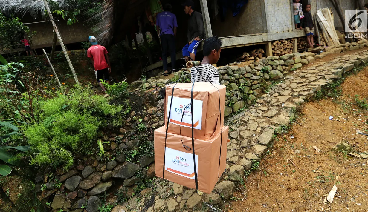 Masyarakat suku Baduy Luar berjalan kaki membawa bantuan berupa perabotan rumah tangga dari Bank BNI senilai 100 juta untuk korban kebakaran Kampung Cisaban II, Desa Kanekes, Banten, Kamis (01/6). (Liputan6.com/Fery Pradolo)