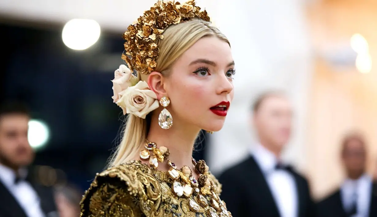 Anya Taylor-Joy sukses bikin publik terkesima saat hadiri Met Gala 2018 lalu. Ia tampil memesona dengan gaun Dolce & Gabbana berhias renda emas dengan hiasan kepala penuh bunga. (Liputan6.com/IG/@anyataylorjoy)