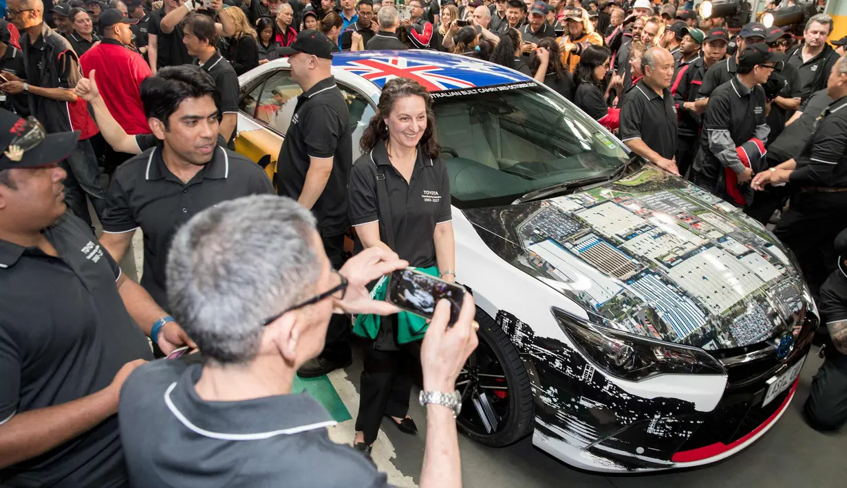 Para karyawan berkumpul di dekat mobil Toyota Camry hybrid di pabrik Altona, Melbourne, Australia (3/10). Pabrik Altona  sudah mengeluarkan sekitar 3,5 juta kendaraan dalam 54 tahun. (Toyota Australia via AP)