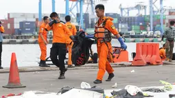 Petugas mengangkat kantung jenazah korban jatuhnya pesawat Lion Air PK LQP di Pelabuhan JICT 2, Jakarta, Senin (5/11). Hingga hari kedelapan jatuhnya pesawat Lion Air PK-LQP, tim SAR gabungan terus mencari korban. (Liputan6.com/Helmi Fithriansyah)