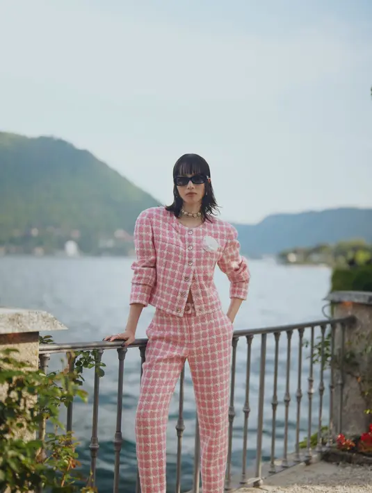 Kemudian, Nana Komatsu tampil fresh dengan setelan tweed warna pink bermotif plaid dan berhiaskan bunga di dada-nya.  [Dok/Chanel].
