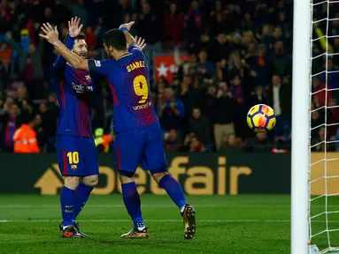 Pemain Barcelona, Lionel Messi merayakan gol rekan setimnya, Luis Suarez ke gawang Deportivo La Coruna pada pertandingan pekan ke-16 La Liga di Stadion Camp Nou, Senin (18/12). Barcelona unggul 4-0 lewat dua gol Suarez.  (AP/Manu Fernandez)