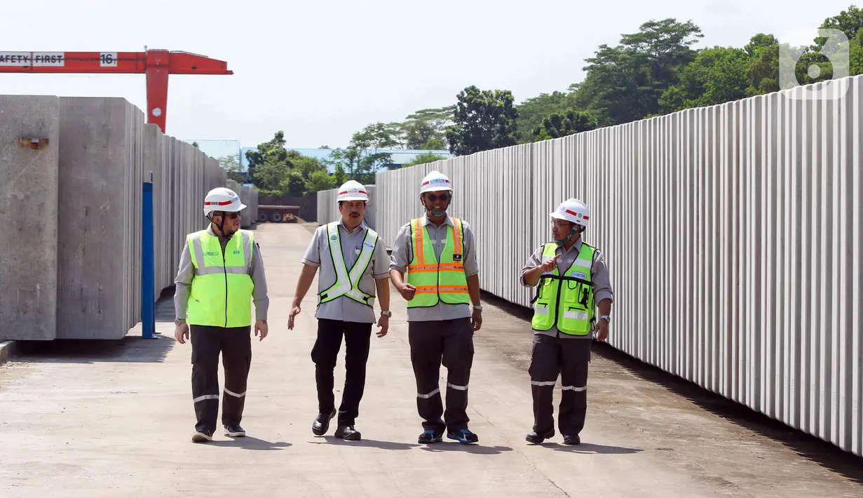 Direktur Utama Wika Beton Kuntjara (kedua kanan), Direktur HR, SSHE dan Asset PT KCIC Adhi Priyanto (kedua kiri), Manajer Unit Mobile Concrete Slab Track Wika Beton Mukhlis (kanan) dan Direktur Teknik Produksi Wika Beton Sidiq Purnomo berbincang saat meninjau slab track di pabrik Slab Track PT Wika Beton, Karawang, Jawa Barat, Rabu (18/5/2022). (Liputan6.com/Herman Zakharia)