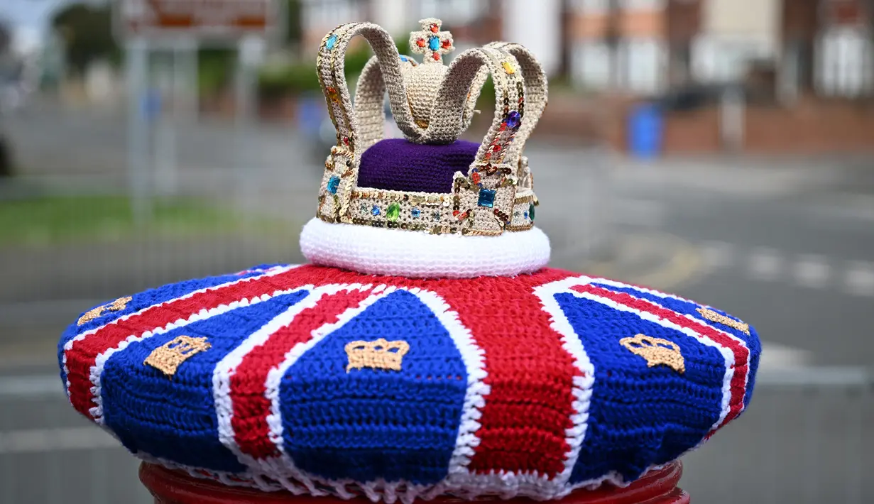Sebuah foto yang diambil pada 2 Mei 2023 memperlihatkan mahkota rajutan yang dipajang di kotak pos di sebelahnya, menjelang penobatan Raja Charles III dan Permaisuri Camilla, di Rhyl, Wales utara. (Photo by Paul ELLIS / AFP)