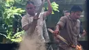 Memasak kari ini menggunakan wajan yang besar dengan api dari kayu bakar. (Chaideer Mahyuddin/AFP)