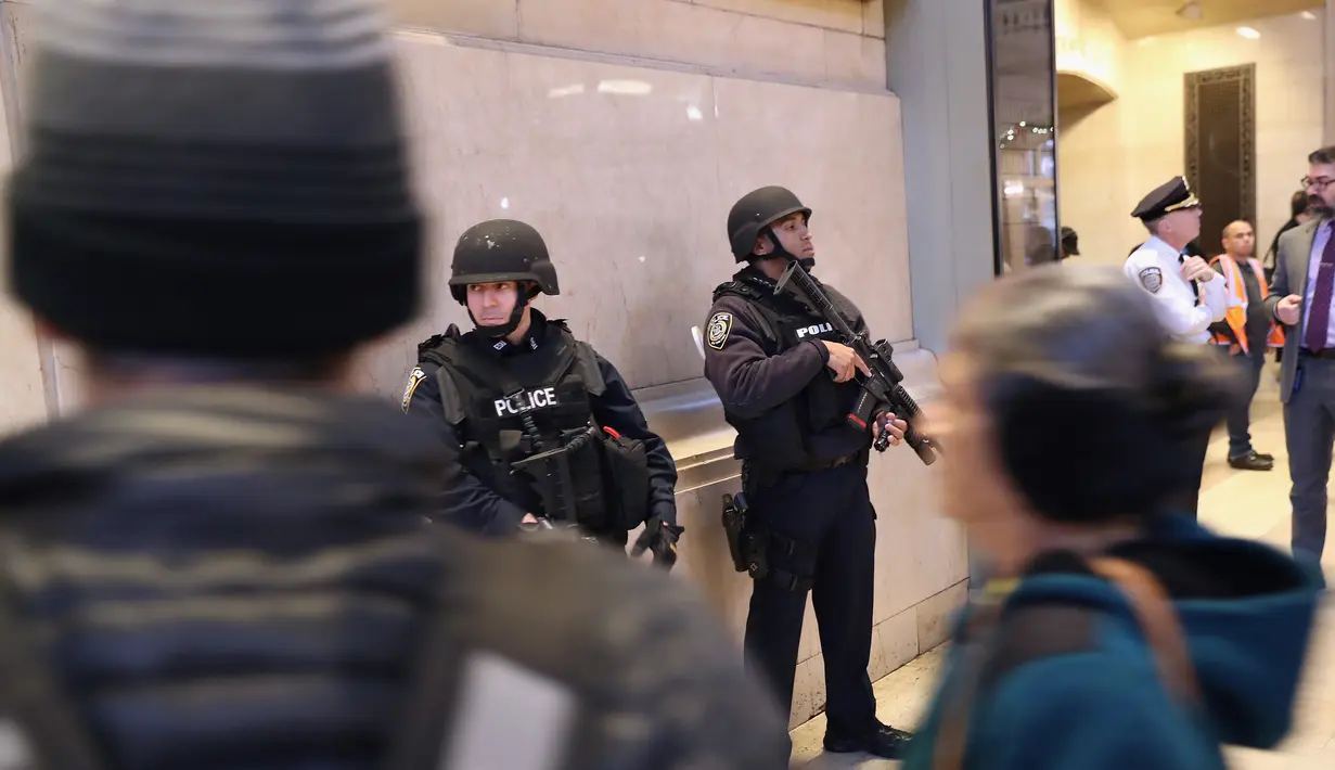 Polisi bersenjata lengkap berjaga di terminal Grand Central, New York City, pasca teror bom pipa, Senin (11/12). Imigran asal Bangladesh, Akayed Ullah (27), menjadi tersangka pelaku ledakan. (JOHN MOORE / GETTY IMAGES NORTH AMERICA / AFP)
