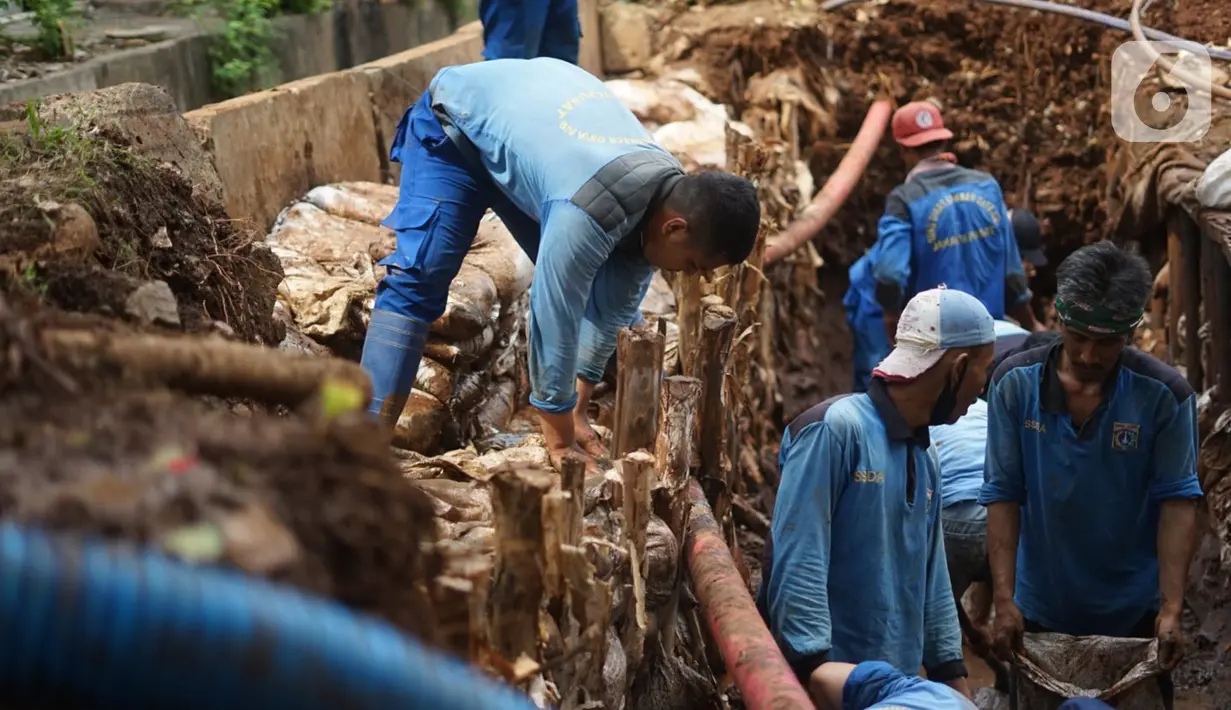 Petugas menyelesaikan pembuatan sumur resapan di kawasan Cempaka Putih, Jakarta, Rabu (25/11/2020). Sebanyak 14 lubang sumur resapan yang dibangun di ruas Jalan Jenderal Ahmad Yani dan Cempaka Putih Barat 21 saat ini terus dikebut pengerjaannya. (Liputan6.com/Immanuel Antonius)