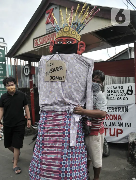 Warga memajang ondel-ondel mengenakan masker di depan pintu masuk permukiman RT 12 RW 14, Cipinang Besar Utara, Jakarta, Kamis (16/4/2020). (merdeka.com/Iqbal S. Nugroho)