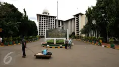 Pedagang melintas di depan pintu masuk utama Masjid Istiqlal Jakarta, Kamis (3/11). Jelang demo besar besaran Jumat (4/11), aktivitas warga di Masjid Istiqlal terlihat normal dan kondusif. (Liputan6.com/Helmi Fithriansyah)