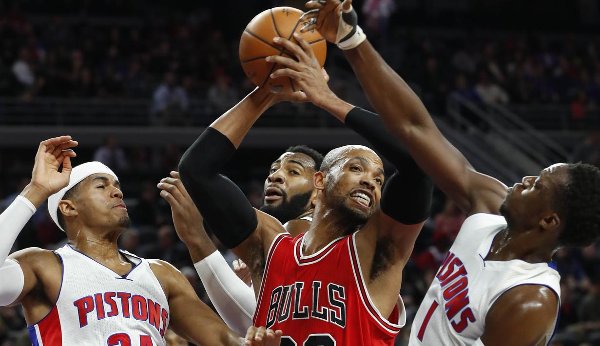Ekspresi pemain Chicago Bulls, Taj Gibson (tengah) saat mendapat adangan dari para pemain Detroit Pistons pada laga NBA di Auburn Hills, (07/12/2016). (AP/Paul Sancya)
