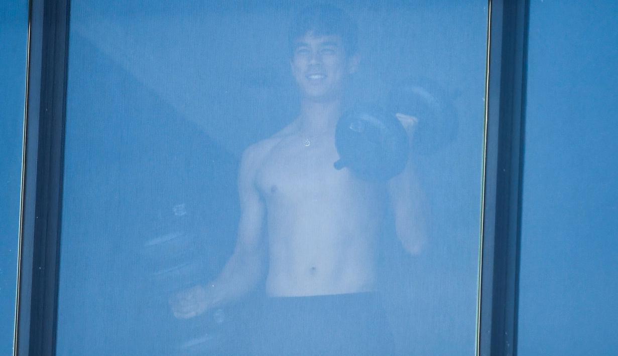 Petenis melakukan latihan angkat beban dikamar hotel saat menjalani karantina selama dua minggu setelah kedatangannya di Melbourne, Minggu (17/1/2021). (Foto: AFP/William West)