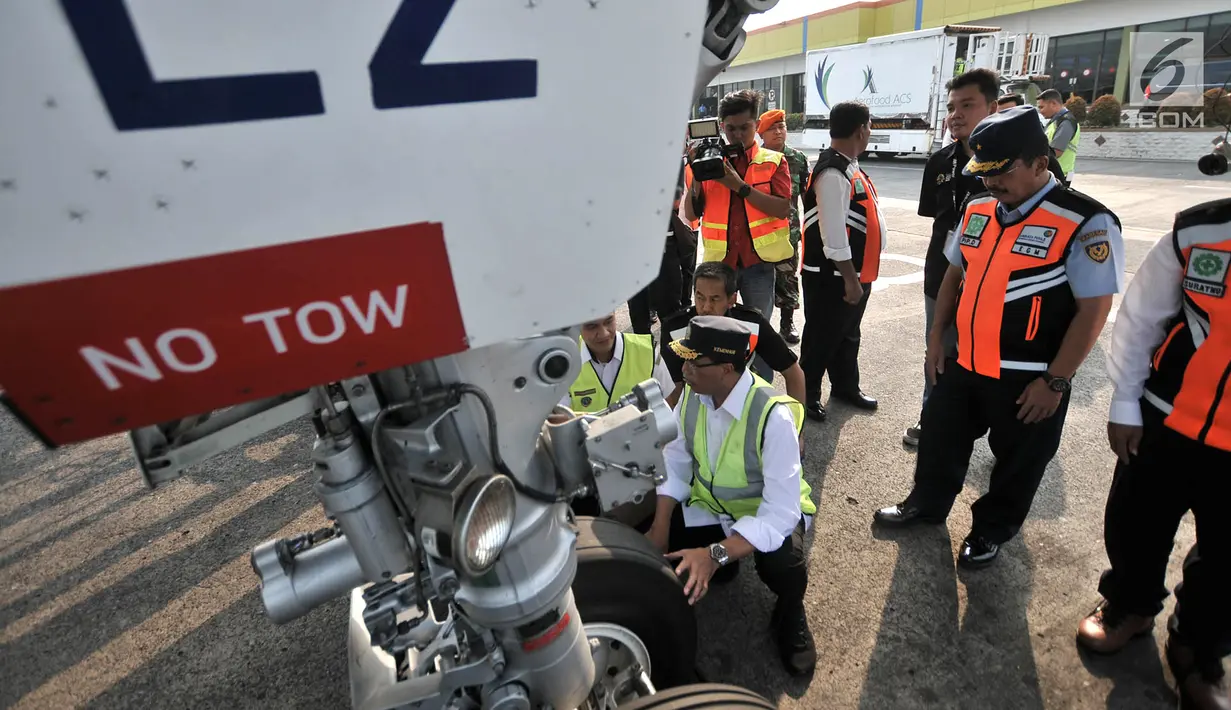 Menteri Perhubungan (Menhub) Budi Karya Sumadi mengecek roda pesawat saat meninjau pelayanan arus mudik di Bandara Halim Perdanakusuma, Jakarta, Senin (11/6). (Merdeka.com/Iqbal Nugroho)