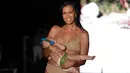 Model Mara Martin berjalan di atas runway sambil menyusui bayinya mengenakan pakaian renang Sports Illustrated pada Miami Swim Week 2018 di Florida, Minggu (15/8). Mara adalah salah satu finalis yang terpilih untuk tampil pada acara itu. (AP/Lynne Sladky)
