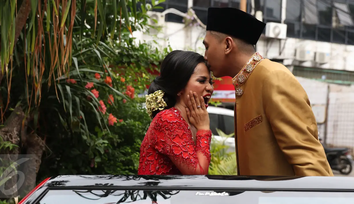 Ajie Pujien mencium kening sang istri yang juga komedian, Chika Waode saat akan meninggalkan KUA Gambir, Jakarta, Rabu (11/5). Setelah menikah, pasangan yang sudah pacaran selama 4 tahun itu akan menggelar resepsi di Padang. (Liputan6.com/Herman Zakharia)
