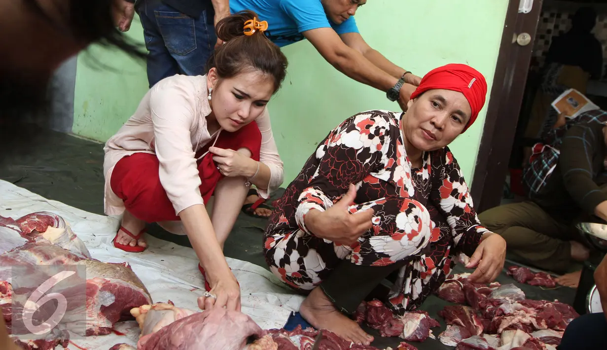 Penyanyi Dangdut Ayu Ting Ting melihat daging kurban dikediamannya kawasan Depok, Jawa Barat, Senin (12/9). Ayu Ting Ting tahun ini berkurban dua ekor sapi. (Liputan6.com/Herman Zakharia)
