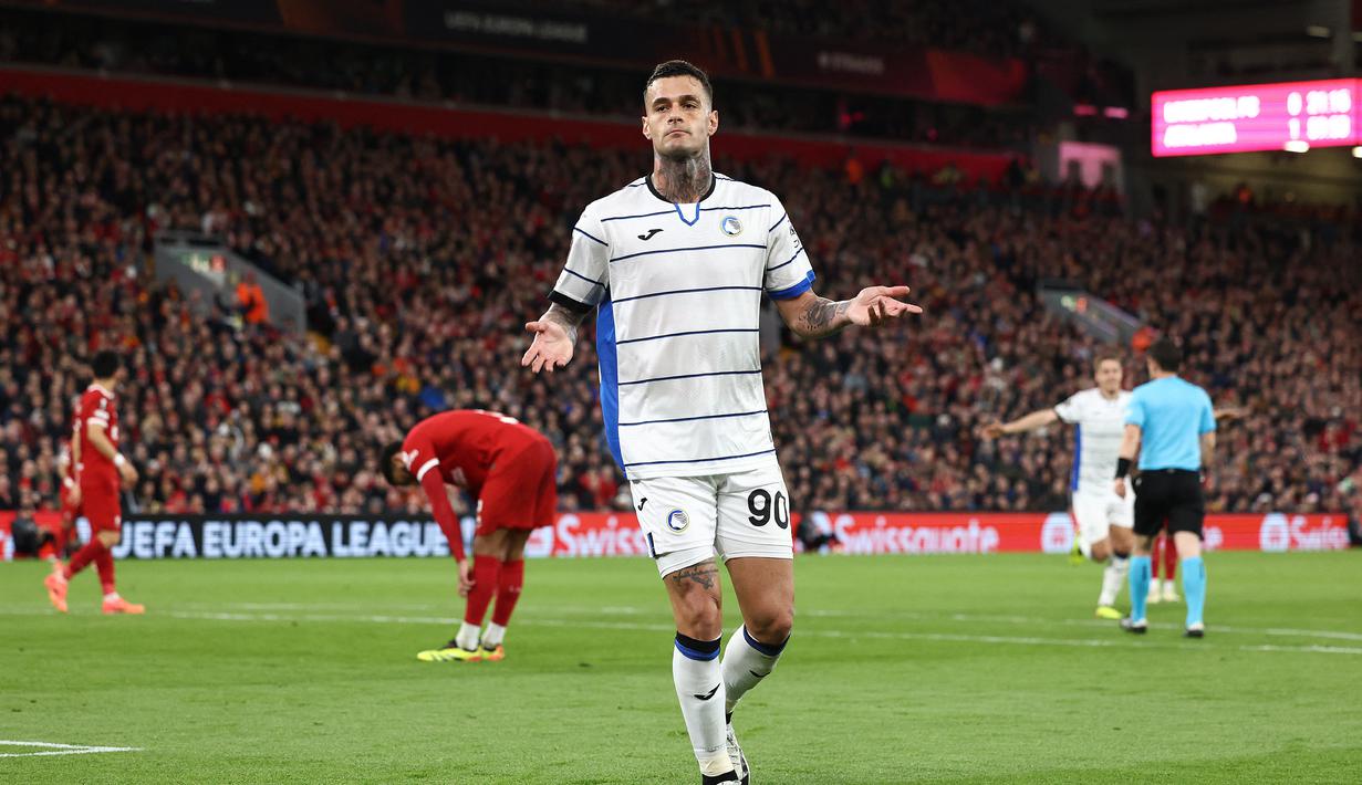 Penyerang Atalanta, Gianluca Scamacca, berselebrasi setelah menjebol gawang Liverpool untuk kali kedua dalam kemenangan 3-0 yang diraih timnya di Anfield pada leg pertama perempat final Liga Europa, Jumat (12/4/2024) dini hari WIB. (Darren Staples / AFP)