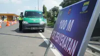 Petugas gabungan memeriksa kendaraan yang memasuki Kota Bandung dari Gerbang Tol Pasteur, Kota Bandung, Kamis (6/5/2021). Pemyekatan tersebut dilakukan selama larangan mudik lebaran 2021. (Liputan6.com/Huyogo Simbolon)