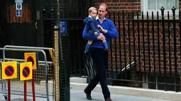 Pangeran William tampak menggendong putra pertamanya, George, menuju Lindo Wing RS St Mary, London, Sabtu (2/5/2015). George pertamakalinya diajak bertemu adik kecilnya yang baru lahir. (REUTERS/Suzanne Plunkett)