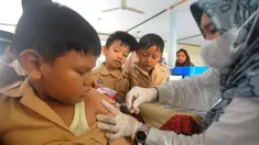 Petugas dari Pusat Kesehatan Masyarakat menyuntikkan vaksin Difteri Tetanus (DT) kepada murid kelas 5 Sekolah Dasar Islam Al Hidayah Cinere, Depok, Jawa Barat, Rabu (20/11/24). (merdeka.com/Arie Basuki)