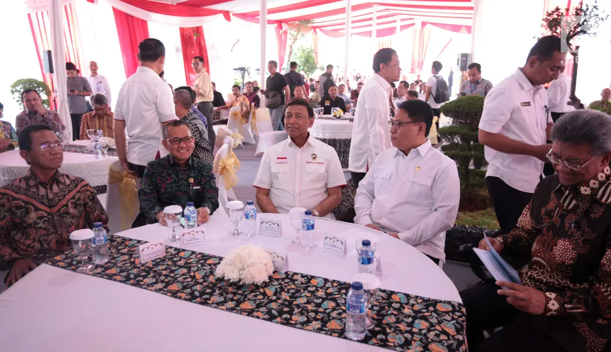 Menko Polhukam Wiranto (tengah) didampingi Ketua LPSK Abdul Haris Semendawai (dua kanan) menandatangani berkas saat memberi kompensasi kepada sejumlah perwakilan korban terorisme di Kantor LPSK, Jakarta, Kamis (6/9). (Liputan6.com/Faizal Fanani)