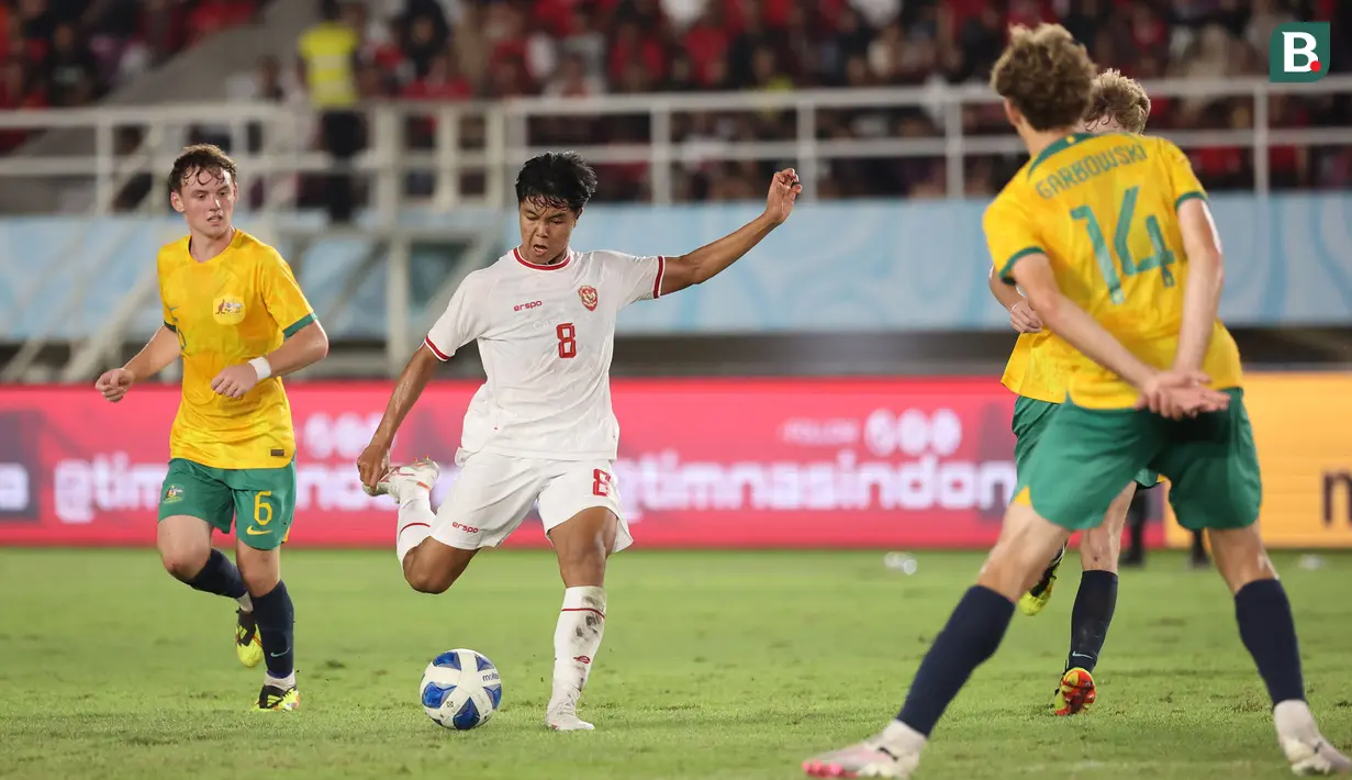 <p>Gelandang Timnas Indonesia U-16, Nazriel Alfaro (tengah) melepaskan tendangan yang berusaha diblok bek Timnas Australia U-16, Alexander Lech Garbowski pada laga semifinal Piala AFF U-16 2024 di Stadion Manahan, Solo, Senin (1/7/2024). (Bola.com/Abdul Aziz)</p>
