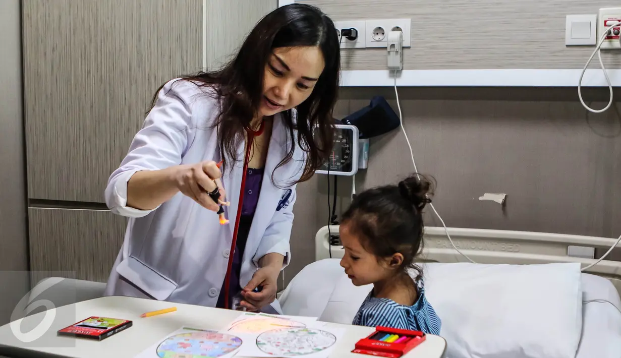 Seorang dokter membimbing pasien anak untuk mewarnai kertas bergambar telur Paskah di Rumah Sakit Siloam Simatupang, Jakarta, Minggu (27/3). Program "Stress Relief" ini membantu memulihkan pasien. (Liputan6.com/Fery Pradolo)