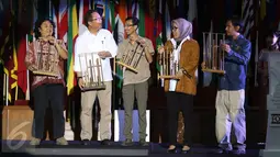 Menteri Komunikasi dan Informatika (Menkominfo) Rudiantara (kedua kiri) memainkan angklung sebagai simbolis pembukaan Anugerah Pewarta Foto Indonesia (APFI) 2016 di Gedung Merdeka, Bandung, Sabtu (9/4). (Liputan6.com/Immanuel Antonius)