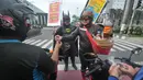 Warga mengenakan kostum superhero Gundala dan Batman menawarkan Jamu saat melakukan aksi sosialisasi pencegahan virus corona di Solo, Rabu (4/3/2020). Indonesia pada 2 Maret melaporkan kasus pertama virus corona yang menimpa dua warga Depok, Jawa Barat. (AFP Photo/Anwar Mustafa)