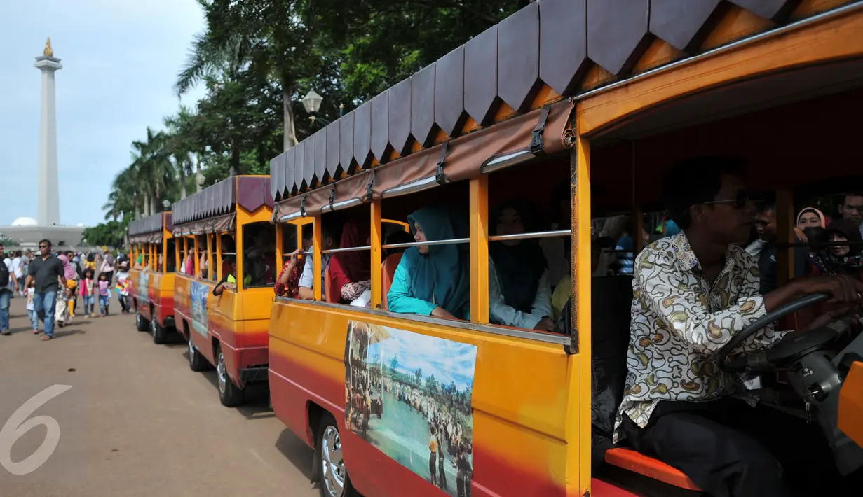 Pengelola Monas menyediakan mobil gandeng untuk berkeliling di kawasan Monas, Jakarta, Sabtu (26/12/2015). Akses yang mudah dan harga yang murah menjadi alasan warga menjadikan Monas tujuan wisata mereka. (Liputan6.com/Yoppy Renato)