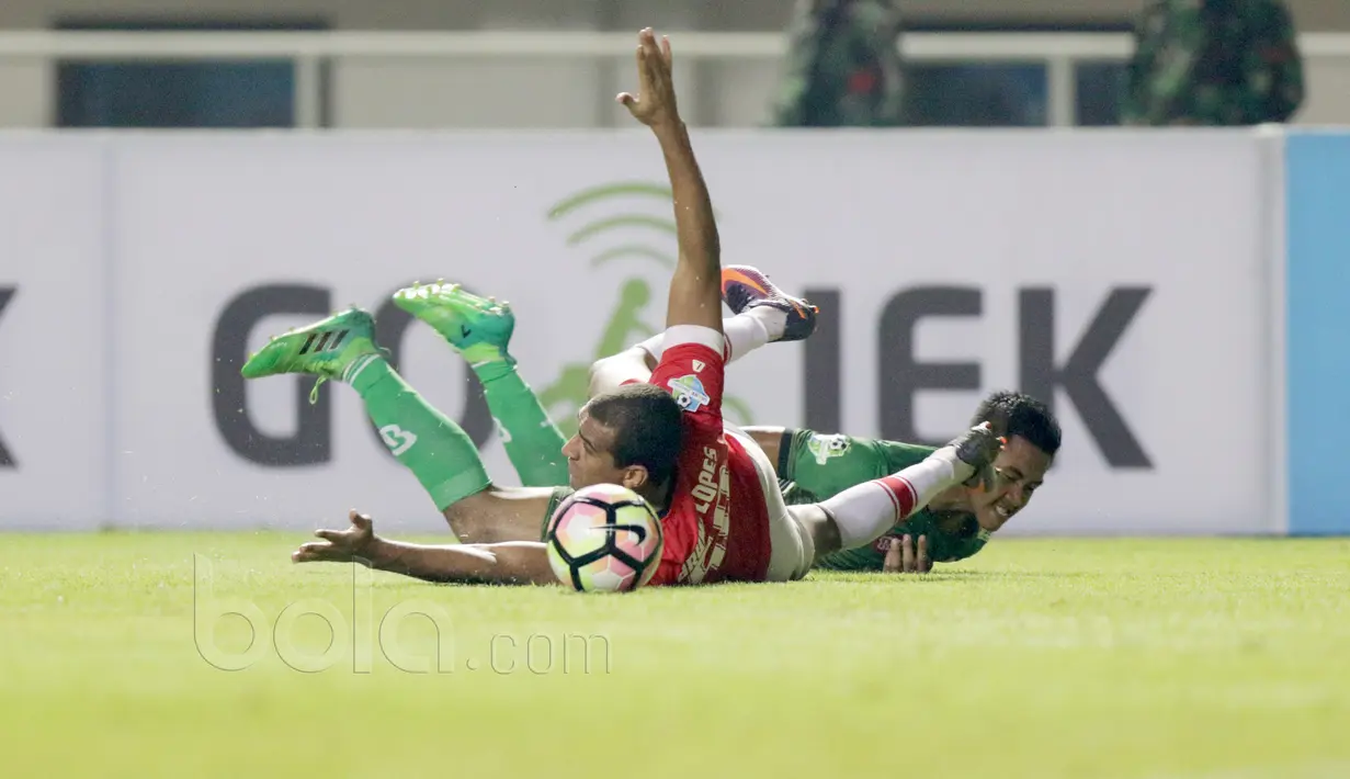 Pemain PS TNI, Ganjar Mukti dan pemain Persija, Bruno Silva (kiri)  terjatuh usai duel pada laga Liga 1 2017 di Stadion Pakansari, Bogor, (8/6/2017). (Bola.com/Nicklas Hanoatubun)