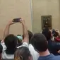 Orang-orang berebutan melihat lukisan Mona Lisa. (Liputan6.com/Ramdania El Hida)