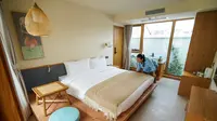 Seorang staf merapikan tempat tidur di Hotel Gusu Yard di Suzhou, Provinsi Jiangsu, China Timur (29/7/2020). Hotel Gusu Yard, sebagai nama penginapan berkualitas tinggi, telah mendirikan empat cabang di kota tersebut dan berencana membangun lebih dari 80 cabang baru di masa mendatang. (Xinhua/Li Bo)
