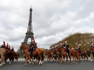 Pasukan berkuda Prancis membentuk formasi saat melintas di depan Menara Eiffel dalam parade kuda ke-20 di Paris, Prancis (19/11). Acara ini menjadi ajang untuk berkumpul bagi mereka pecinta kuda. (AFP Photo/Thomas Samson)