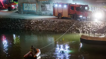 Regu penyelamat mencari korban kecelakaan mobil di kanal di bawah jembatan jalan raya E4 di Sodertalje, Swedia, Sabtu (13/2). Empat anggota band Viola Beach dari Inggris dan manajernya tewas dalam kecelakaan tersebut. (JOHAN NILSSON/TT NEWS AGENCY/AFP)