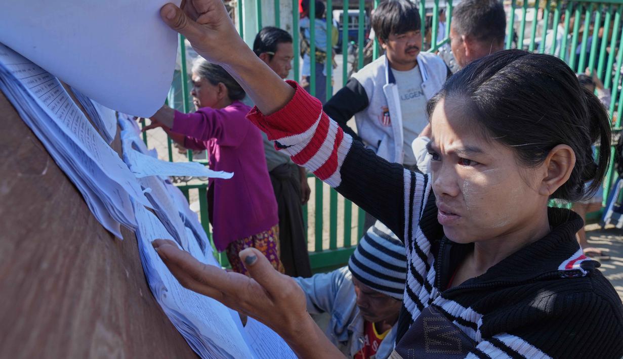 Sebagai informasi, Myanmar, yang berpenduduk sekitar 50 juta jiwa, masih terbelah gara-gara perang saudara. Tampak dalam foto, orang-orang mencari nama mereka di daftar pemilih yang dipajang di luar tempat pemungutan suara di Naypyitaw, Myanmar, Minggu, 28 Desember 2025. (AP Photo/Aung Shine Oo)