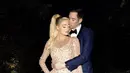 Paris tampil mengenakan gaun bodycon warna nude transparan dengan detail manik-manik. Sedangkan sang suami dengan setelan suitnya.(@parishilton)