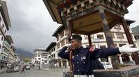 Seorang polisi Bhutan memberi isyarat saat mengarahkan lalu lintas di Thimphu pada 21 Maret 2008. (DESHAKALYAN CHOWDHURY / AFP)
