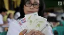 Petugas Dukcapil Jakarta Pusat menunjukkan Surat Keterangan Domisili Sementara (SKDS) milik warga pendatang yang telah selesai dibuat dalam Bina Kependudukan (Biduk) di Pal Putih, Kramat, Senen, Jakarta, Rabu (10/7/2019). (merdeka.com/Iqbal Nugroho)