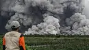 Masyarakat dilarang melakukan aktivitas apa pun dalam radius 20 kilometer dari puncak, terutama di sepanjang aliran Besuk Kobokan, karena adanya ancaman lahar dan awan panas. Tampak dalam foto, seorang pria memandang aliran piroklastik selama letusan Gunung Semeru di Lumajang, Jawa Timur, pada Rabu 19 November 2025. (Agus Harianto/AFP)