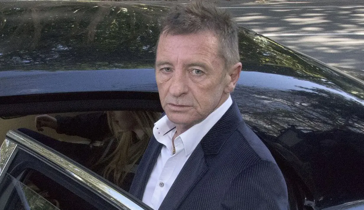 Mantan drummer AC/DC Phil Rudd meninggalkan pengadilan di Tauranga, Selandia Baru, Kamis (9/7/2015). Phil dijatuhi hukuman 8 bulan tahanan rumah setelah mengaku bersalah mengancam membunuh seorang pria yang pernah bekerja untuknya. (AFP/Marty Melville)
