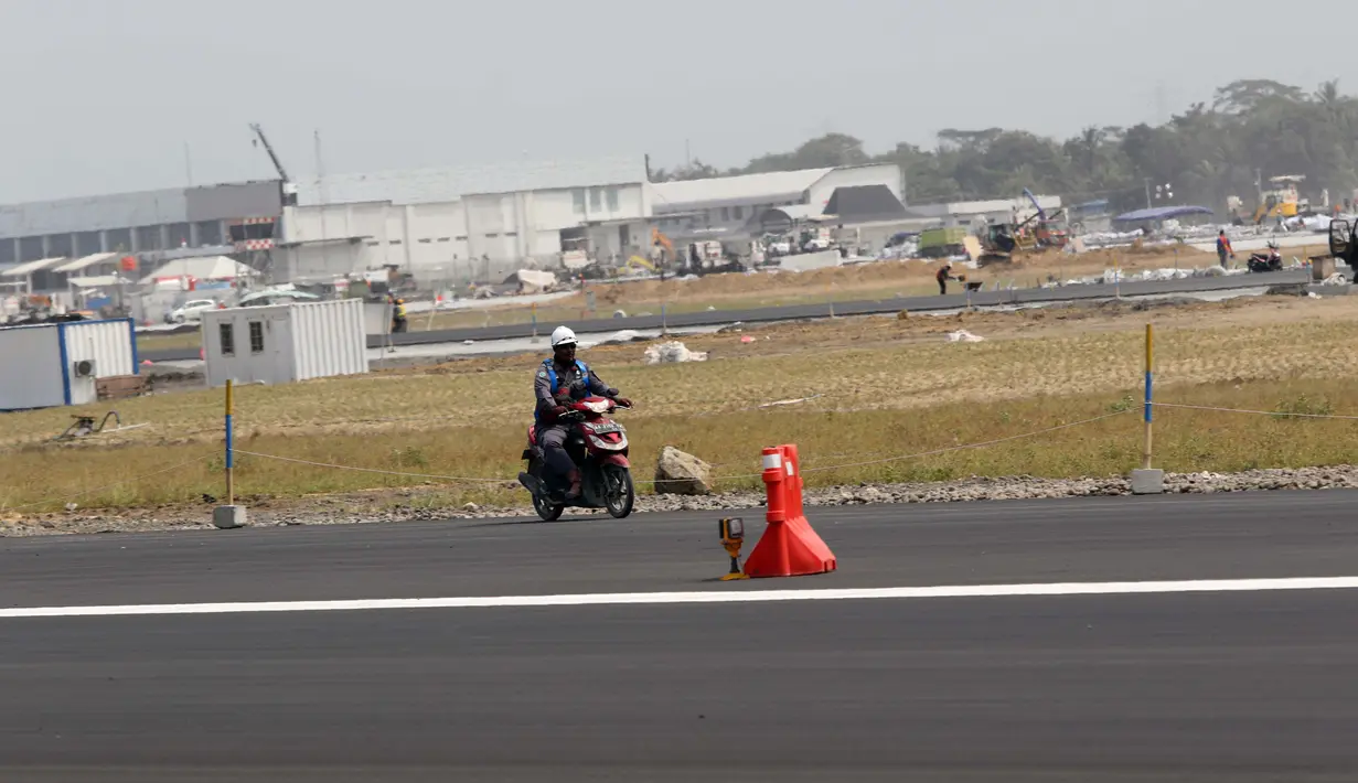 Pekerja melintasi sisi landasan pacu atau runway Bandara Internasional Yogyakarta, Kulon Progo, DI Yogyakarta, Rabu (24/4). Landasan pacu Bandara Internasional Yogyakarta memiliki panjang 3.250 meter dengan lebar 45 meter. (Liputan6.com/Helmi Fithriansyah)