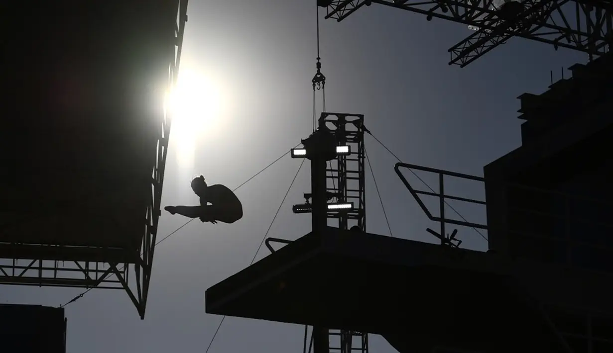 Siluet seorang peloncat indah saat penyisihan nomor menara 10m putri di Maria Lenk Aquatics Stadium, Rio de Janeiro, Brasil, (17/8/2016). (AFP/Martin Bureau)