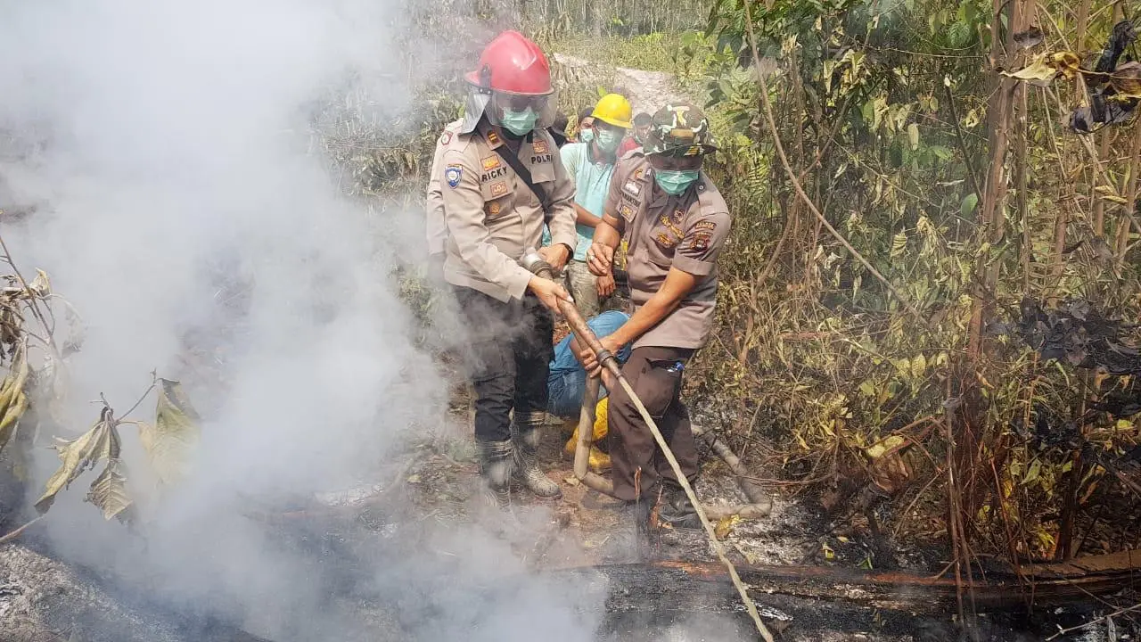 Polisi anggota Satgas Karhutla memadamkan api di hutan dan lahan yang terbakar, Selasa (27/8/2019).