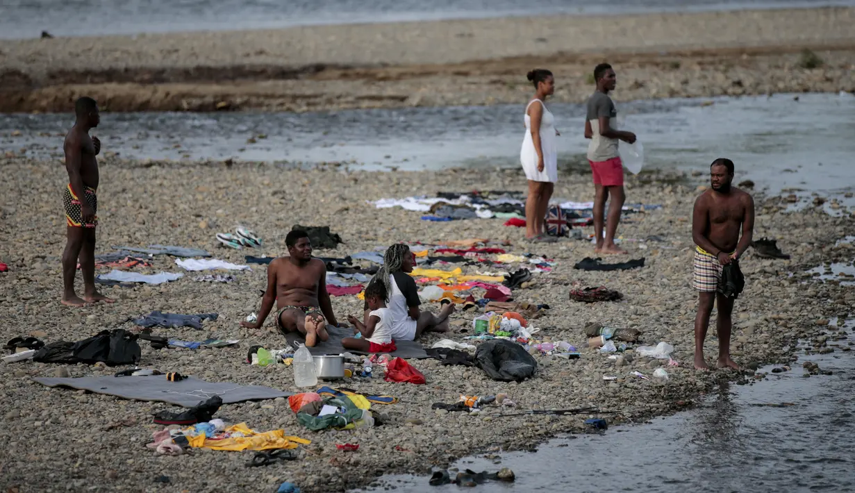 Sekelompok imigran beristirahat di Sungai Tuquesa, Desa Bajo Chiquito, Provinsi Darien, Panama, 22 Agustus 2021. Panama dan Kolombia mencapai kesepakatan untuk mengendalikan banjir imigran yang melintasi perbatasan bersama ke Amerika Serikat. (ROGELIO FIGUEROA/AFP)
