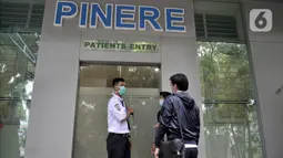 Pengunjung berbincang dengan petugas keamanan di depan ruang isolasi pasien virus corona atau COVID-19 di Gedung Pinere, RSUP Persahabatan, Jakarta Timur, Rabu (4/3/2020). Sebanyak 10 dari 31 pasien yang dipantau dan diawasi RSUP Persahabatan merupakan pasien rujukan. (merdeka.com/Iqbal Nugroho)