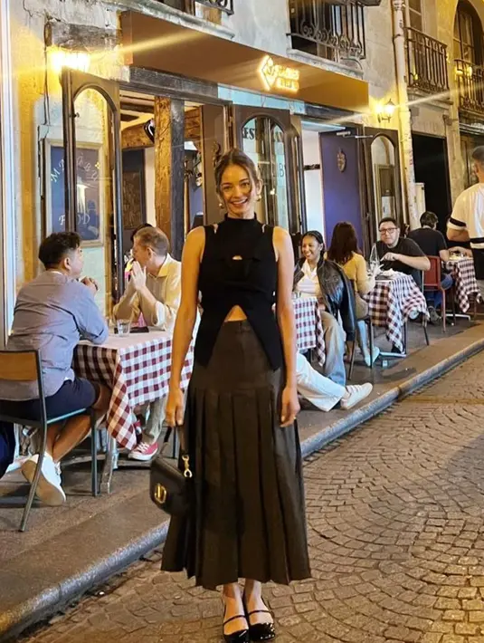 Momen lain memperlihatkan Enzy tampil dengan asymmetric top warna hitam dipadukan pleated mini skirt abu-abu, dan ballerina pumps. Enzy kemudian menyempurnakan penampilannya dengan shoulder bag dari Valentino [@claurakiehl/@enzystoria/@tasyafarasya]