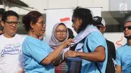 Menteri Kelautan dan Perikanan Susi Pudjiastuti memasangkan syal ke Kaka Slank saat meresmikan  'Pandu Laut Nusantara' sebagai wadah bersama untuk para pemerhati laut di CFD kawasan Bundaran HI, Jakarta, Minggu (15/7). (Liputan6.com/Arya Manggala)
