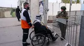Seorang pria Muslim Palestina yang menggunakan kursi roda tiba di pos pemeriksaan Israel di Bethlehem, Tepi Barat yang diduduki Israel, pada 14 Maret 2025. (Hazem BADER/AFP)